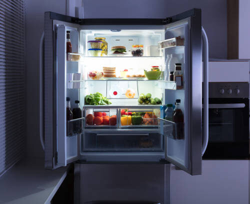 Open Refrigerator Full Of Juice And Fresh Vegetables In Kitchen